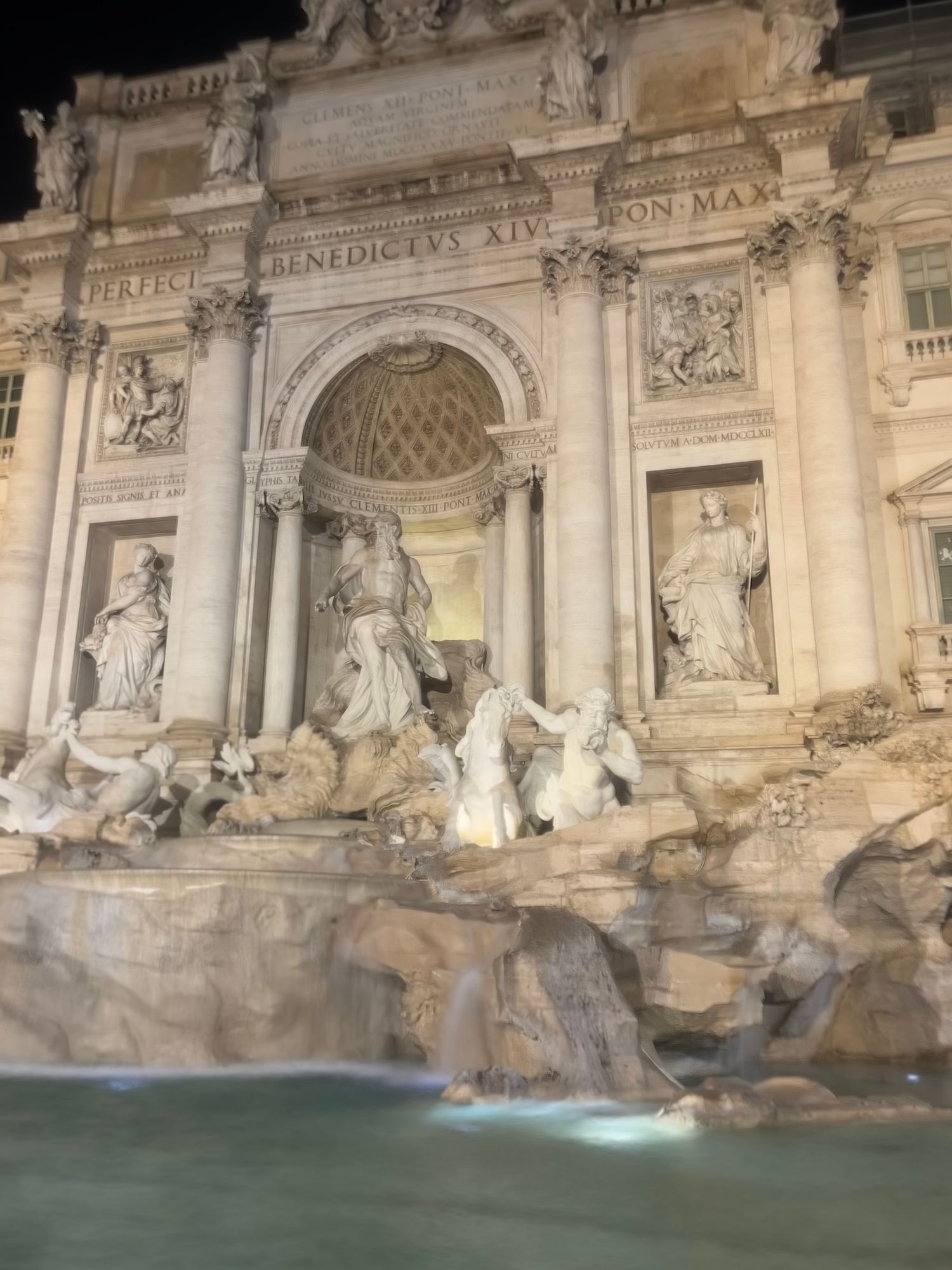 The Trevi Fountain lit up at night.